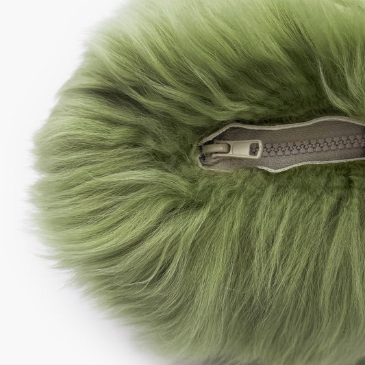 The Mood Charlie Sheepskin Double-sided Pillow in a green-tea color, close-up view of zipper closure