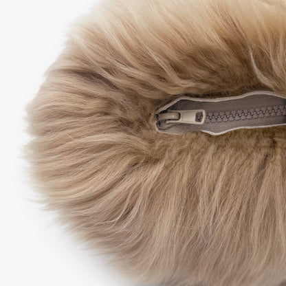 The Mood Charlie Sheepskin Double-sided Pillow in a sandy brown color, close-up view of zipper closure