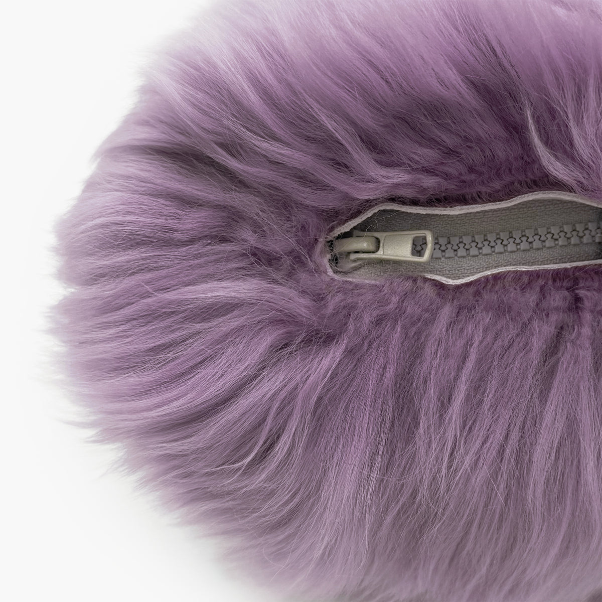The Mood Charlie Sheepskin Double-sided Pillow in a deep mauve purple color, close-up view of zipper closure