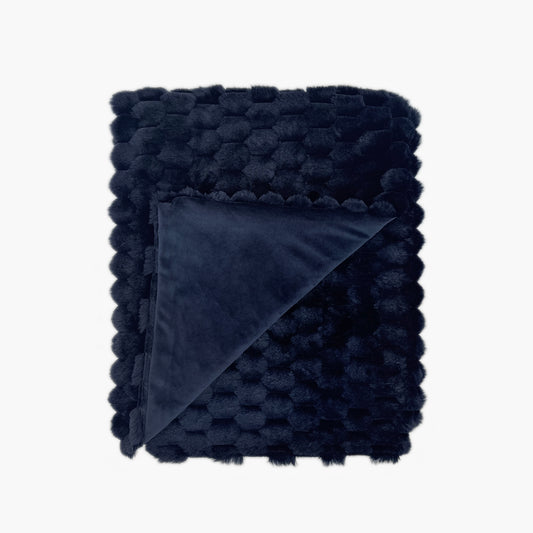 The Mood Honey Faux Fur Throw, 50x60 in., Mid-night Blue; Dark navy honeycomb textured faux fur blanket with a corner folded upward on a white background, showcasing the backing made with velvety minky fabric in matching color