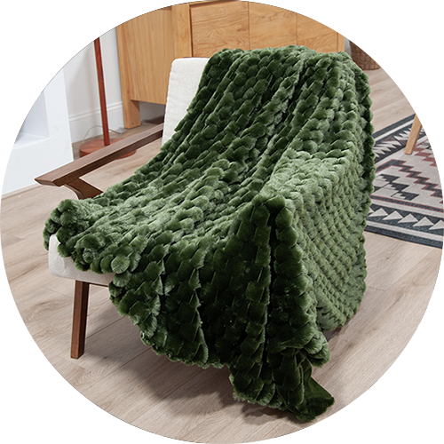 Dark green honeycomb textured blanket draped over an accent chair in a living room, representing the category of 'throw blankets'